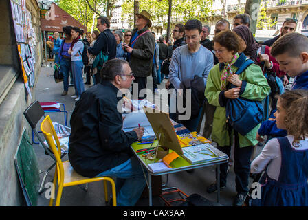 Parigi, Francia, fumettista politico disegno sul marciapiede durante il francese Sindacati dimostrare nel maggio annuale Giorno Marzo, folla street city Foto Stock