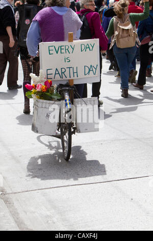 Manifestanti marciano e il ciclista con la Giornata della Terra segno, giorno di maggio Rally, 1 maggio, 2012, Seattle, Washington Foto Stock