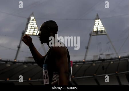 04.05.2012 Londra, Inghilterra. Un atleta esce di pista silouhetted dalle luci dello stadio dopo la concorrenza nelle manche del Mens 100m durante il giorno 1 dell'BUCS Visa Outdoor Athletics Championships nello stadio sul Parco Olimpico. (Questo è un 2012 Olimpiadi evento di prova, parte della London prepara S Foto Stock