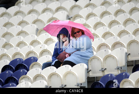 Brighton, Regno Unito. 07 Maggio, 2012. Hove Regno Unito - spettatori riparo sotto gli ombrelloni durante la doccia a pioggia a Probiz County Ground in Hove Foto Stock