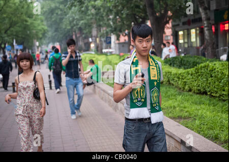 Sostenitore di Pechino Guoan sul suo modo al lo stadio dei lavoratori per la corrispondenza tra il Beijing Guoan e Guizhou Renhe squadre di calcio a Pechino, Cina, Venerdì 11 Maggio, 2012. Guoan Pechino ha vinto la partita con 2:1. Foto Stock