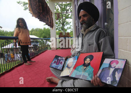 Un Sikh del Kashmir tenere le fotografie dei loro parenti che sono stati uccisi durante il massacro di Chattisinghpora 80km da srinagar, la capitale estiva del Kashmir indiano su 14/5/2012,durante il colloquio con Altaf Zargar Zuma premere fotografo vittime ha detto che anche se 11 anni sono passati ma Foto Stock