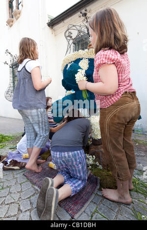 I bambini lavorano insieme per decorare le sculture di filo con narciso e per fare in modo che siano pronti per la parata del 53 Festival di narciso, Bad Aussee, Ausseerland, Stiria, Austria, Sabato 19 Maggio, 2012. Foto Stock