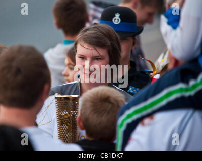 Un runner nella torcia Olimpica attende la sua volta circondato dalla folla, in Plymouth, Devon, Regno Unito - del XIX secolo di maggio 2012. Runner 27 in attesa della consegna. Foto Stock