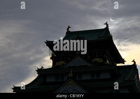 Maggio 21, 2012, Osaka, Giappone - la parziale eclissi solare è visto oltre il castello di Osaka in Osaka, Giappone occidentale il 21 maggio 2012. Un elemento anulare di eclissi solare è stata osservata su una vasta area del Giappone il lunedì mattina presto. Milioni di persone hanno guardato come una rara "l'anello di fuoco' eclipse attraversato i cieli. (Foto Foto Stock