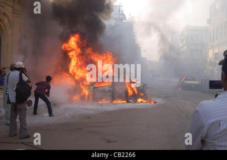 Fiamme di fuoco alzarsi da un ardente veicoli che era stato impostato dal variopinto di miscredenti sconosciuto in una strada durante la continua violenza durante la Awami Tehreek "ohabbat Sindh' rally a Karachi il Martedì, 22 maggio 2012. Foto Stock