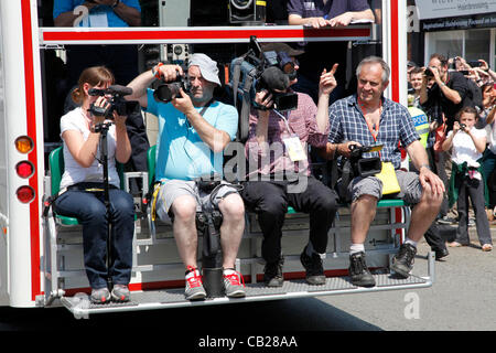 Mercoledì, 23 maggio 2012. Swindon, Wiltshire, Inghilterra, Regno Unito. Fotocamera e troupes televisive ride di fronte alla torcia olimpica portatori attraverso la Città Vecchia in Swindon Foto Stock