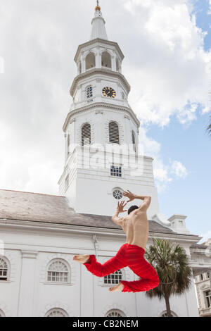 I Kanji Segawa un ballerino con la Alvin Ailey American Dance Theater esegue durante le cerimonie di apertura per il Festival di Spoleto negli Stati Uniti con la storica chiesa di San Michele in background il 25 maggio 2012 a Charleston, Carolina del Sud. Il 17-giorno performing arts festival comprenderà più di 140 perf Foto Stock