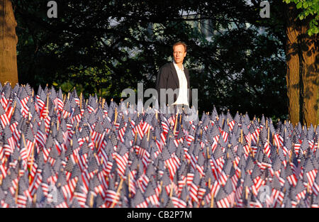 Un uomo si affaccia su un campo di bandiere su Boston Common a Boston, Massachusetts, all'inizio del Memorial Day weekend negli Stati Uniti, Venerdì, 25 maggio 2012. Il Massachusetts eroi militari Fund piantati i 33.000 bandiere in memoria del Massachusetts militari che hanno perso la vita in servizio dal th Foto Stock