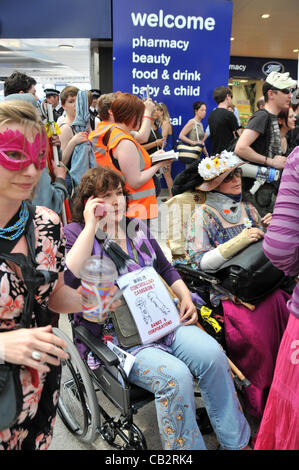 La stazione di Waterloo, Londra, Regno Unito. Il 26 maggio 2012. I manifestanti in carrozzina e alcune con maschere di protesta contro il governo taglia di vantaggi come Regno Unito intonso manifestanti per assemblare il 'Grande British Street Party". Linea di credito : credito: Matteo Chattle / Alamy Live News Foto Stock