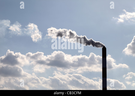 Ciminiere industriali con fumo le nuvole nel cielo blu Foto Stock