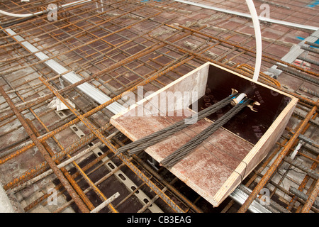 Post-tensionamento dei cavi di acciaio nel pavimento in calcestruzzo cassaforma Foto Stock