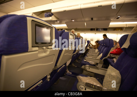 File di sedili con intrattenimento individuale schienale schermi a bordo di una 747 aerei per il trasporto di passeggeri Foto Stock