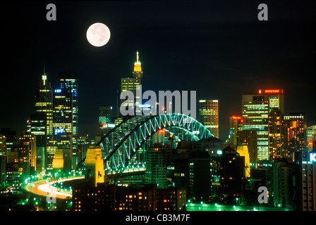 Vista del Ponte del Porto di Sydney in mezzo a città alta sorge dal North Sydney di notte sotto la luna piena Foto Stock