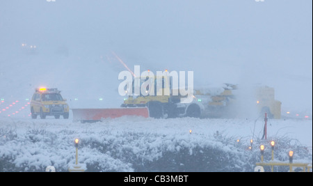 Spazzaneve battaglia per cancellare neve spessa dall'Aeroporto Gatwick di Londra la pista durante una bufera di neve. Foto Stock