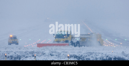 Spazzaneve battaglia per cancellare neve spessa dall'Aeroporto Gatwick di Londra la pista durante una bufera di neve. Foto Stock