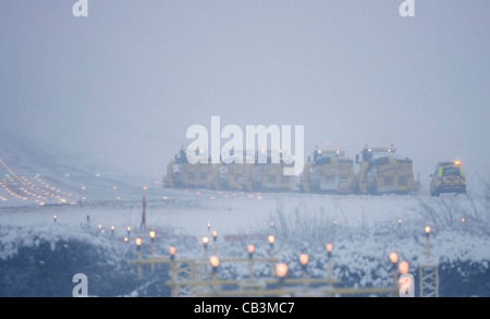 Spazzaneve battaglia per cancellare neve spessa dall'Aeroporto Gatwick di Londra la pista durante una bufera di neve. Foto Stock