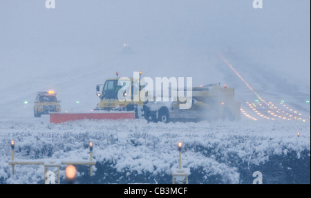 Spazzaneve battaglia per cancellare neve spessa dall'Aeroporto Gatwick di Londra la pista durante una bufera di neve. Foto Stock