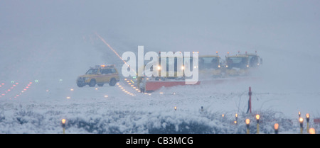 Spazzaneve battaglia per cancellare neve spessa dall'Aeroporto Gatwick di Londra la pista durante una bufera di neve. Foto Stock