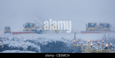 Spazzaneve battaglia per cancellare neve spessa dall'Aeroporto Gatwick di Londra la pista durante una bufera di neve. Foto Stock