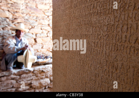 Un custode si siede accanto a re Ezana di iscrizione presso le tombe dei re Kaleb e Gebre Meskel in Aksum, Nord dell'Etiopia. Foto Stock