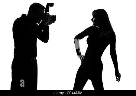 Un caucasian giovane uomo fotografo di fotografare e donna moda modello in posa studio silhouette isolati su sfondo bianco Foto Stock