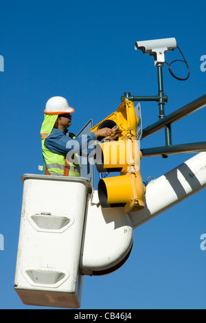 Uomo su elevati cherry picker che fissa le luci del traffico San Antonio Texas Foto Stock