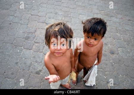 Due affamati di bambini di strada i ragazzi che vivono in povertà hanno bisogno di cibo per le strade di Phnom Penh Cambogia. Foto Stock