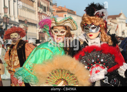 I partecipanti non identificato vestono i tradizionali costumi e maschere, durante il famoso carnevale veneziano. Foto Stock