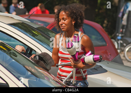 Ragazza giovane guadagnare soldi come jugglery eseguendo sul passaggio pedonale di fronte della Colonna della Vittoria. Berlino, Germania. Foto Stock