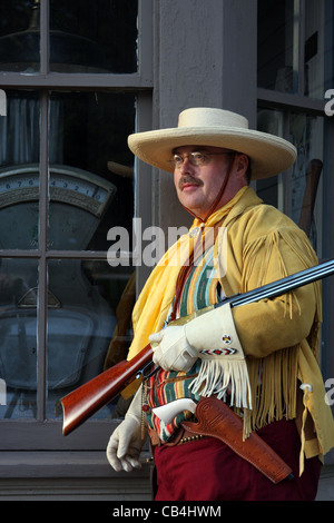 Un cowboy southwestern in piedi di fronte a un vecchio negozio Foto Stock