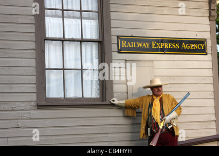 Un cowboy standing sulla parte anteriore di un deposito ferroviario Foto Stock