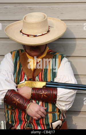 Un cowboy appoggiata contro un edificio Foto Stock