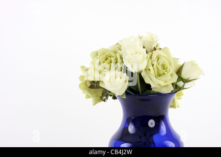 Un vaso blu con un bouquet di fiori bianchi Foto Stock