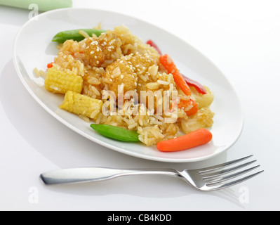 Le carni bianche di pollo con riso, verdure e i semi di sesamo in una salsa di mandarino Foto Stock