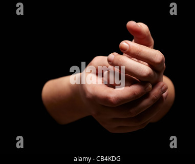 Mani tenendo uno un altro isolato su sfondo nero. Foto Stock