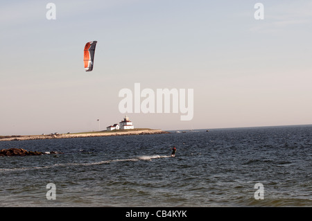 A Kiteboarder watch hill con il faro in background Foto Stock