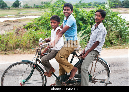 Tre bambini indiani in sella ad una bicicletta. Andhra Pradesh, India Foto Stock