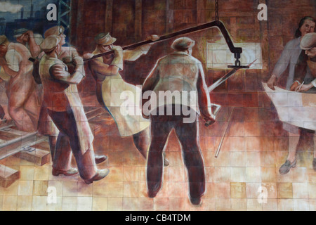 I lavoratori sono mostrati occupato in una fucina in un murale socialista a Berlino, Germania. Foto Stock