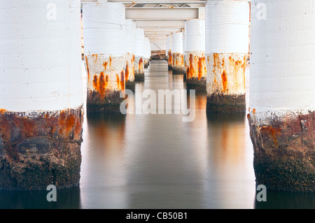 Rusty poli ponte ancora in acqua Foto Stock