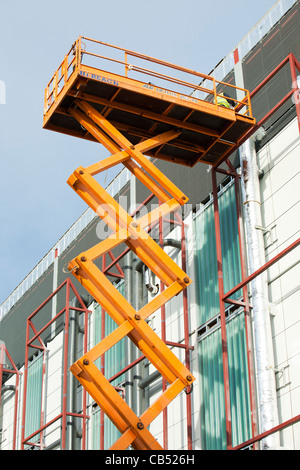 Una piattaforma rialzata utilizzata da operaio in un nuovo edificio nel centro di Manchester, UK. Foto Stock