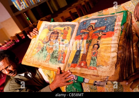 Una cappella custode visualizza un antico manoscritto illuminato presso la nuova chiesa di Santa Maria di Sion in Aksum, Nord dell'Etiopia. Foto Stock