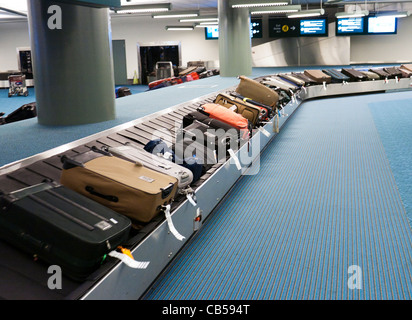 Valigie su un carosello bagagli in un aeroporto Foto Stock