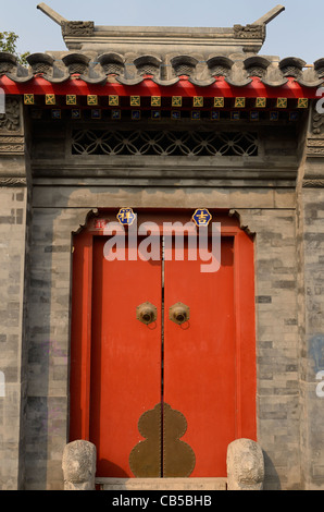 Porta Rossa e la muratura in pietra a tenuta nella zona di Shichahai hutong di Pechino Repubblica Popolare Cinese Foto Stock