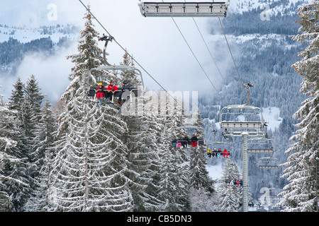 Gli sciatori sulla seggiovia a Les Gets, Haute Savoie, Rhône-Alpes, in Francia Foto Stock