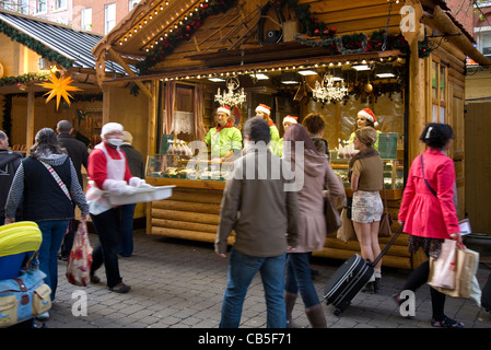 Vendite di natale e la festa di acquirenti acquistano merci in Piccadilly Manchester, Regno Unito Foto Stock