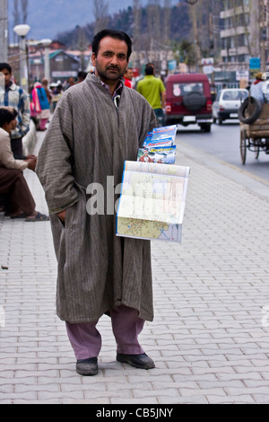 Un uomo Kashmiri in stoffa tradizionale che vende le cose sul sentiero intorno al lago di dal, Srinagar, Kashmir, India Foto Stock