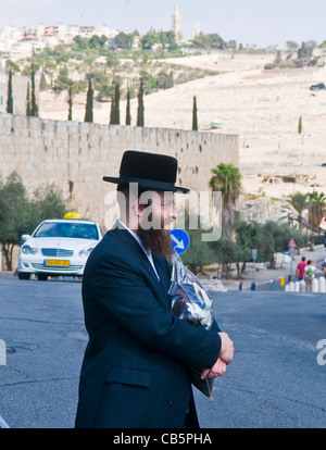 Un ultra- ebrea ortodossa stand uomo vicino alle pareti della vecchia Gerusalemme , Israele Foto Stock