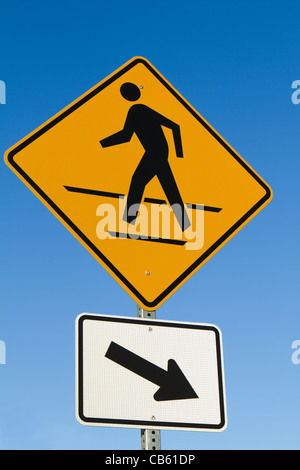 Pedoni crosswalk sign con freccia contro un cielo blu. Foto Stock