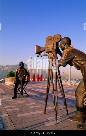 Cina, Hong Kong Kowloon, Tsim Sha Tsui, Avenue of Stars, i produttori statua con skyline della città in background Foto Stock